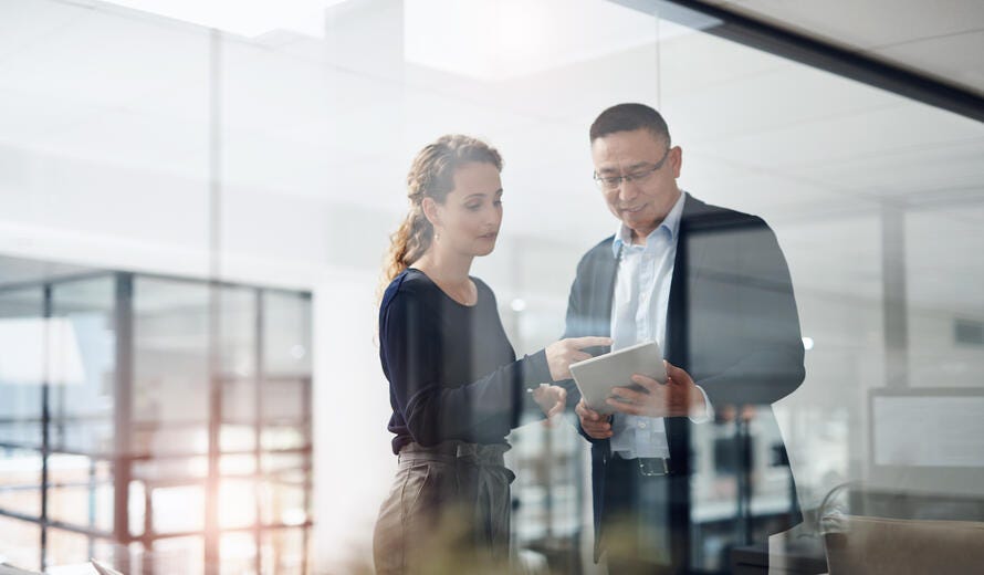 Shot of two businesspeople working together on a digital tablet in an office