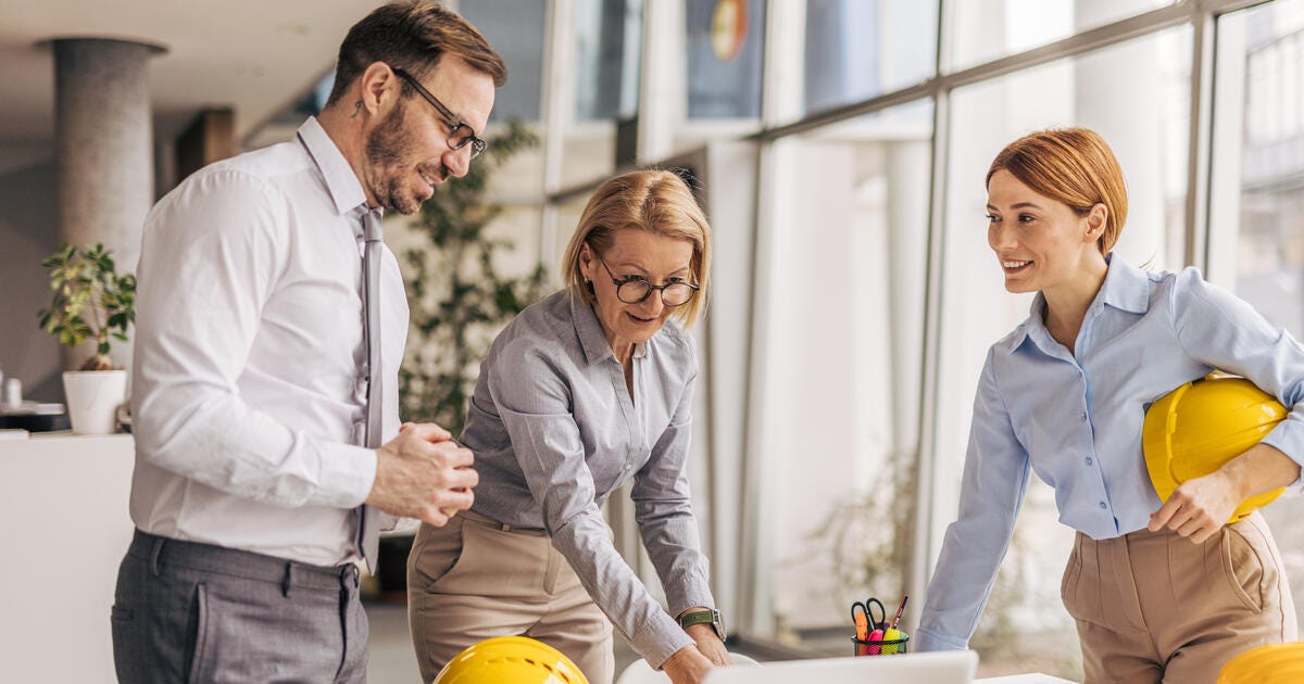 Three architects are working together on a project in their office.
