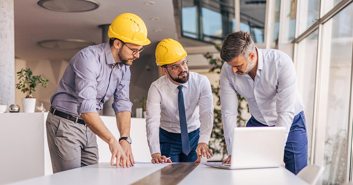 construction workers talking around a table
