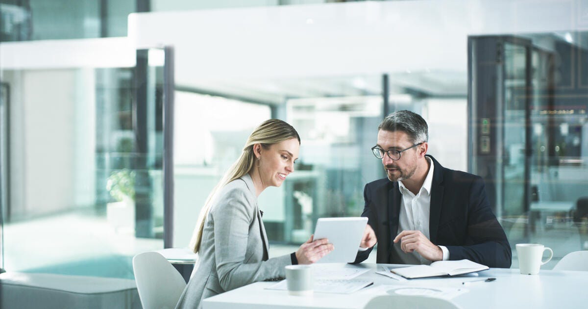 Shot of two businesspeople working together on a digital tablet in an office.