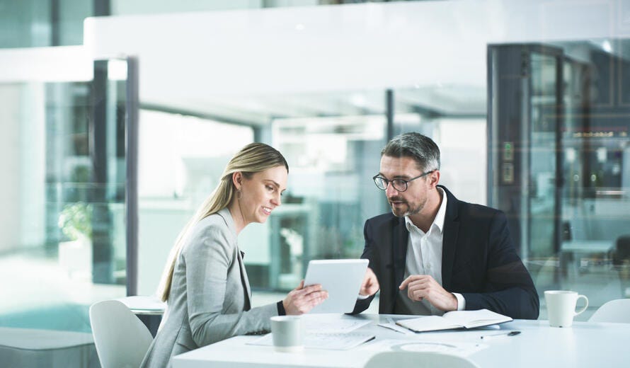 Shot of two businesspeople working together on a digital tablet in an office.