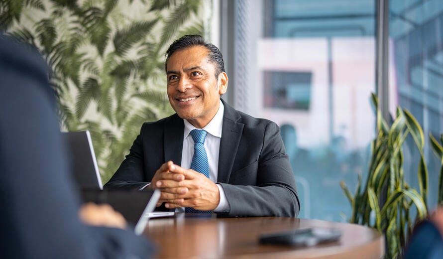 Latin American male businessman sitting at his desk.