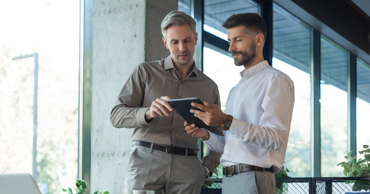 Two diverse business partners standing and discussing project.